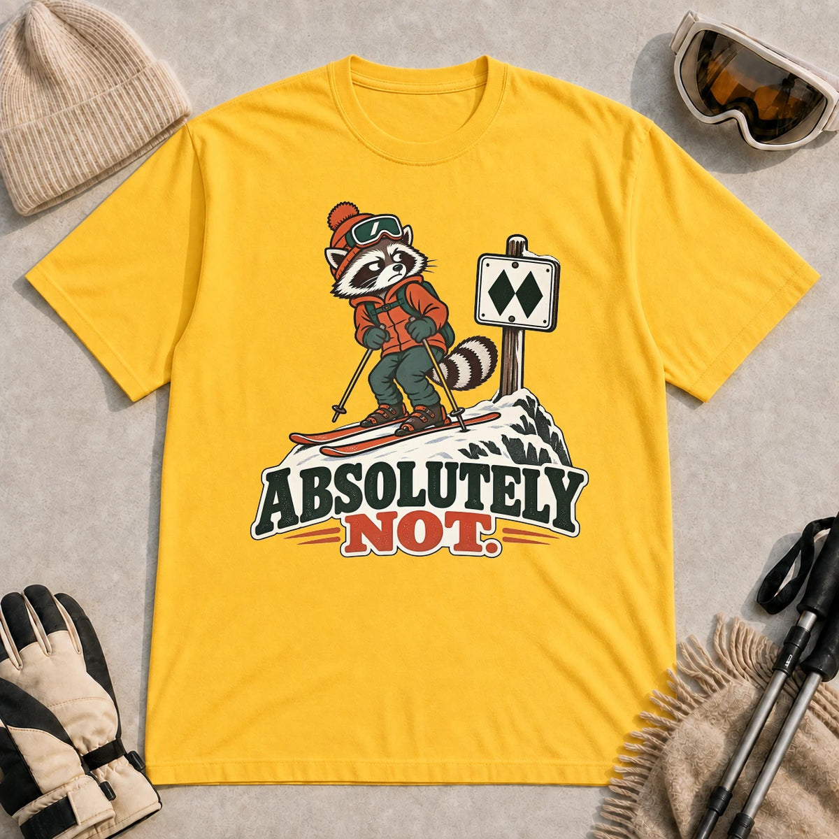 Mustard tee featuring a wary raccoon skier beside a double black diamond trail sign above the phrase “Absolutely Not.”