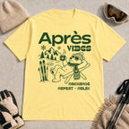 Cornsilk tee featuring a relaxed bear in sunglasses holding a steaming mug beside skis, with retro green “Après Vibes” and “Recharge, Repeat – Relax” text.
