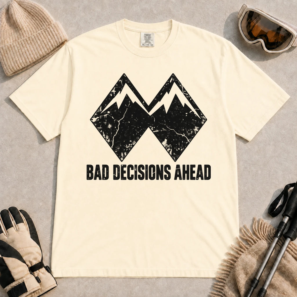 Ivory tee featuring a distressed black double-mountain graphic above the phrase “Bad Decisions Ahead.”