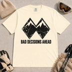 Ivory tee featuring a distressed black double-mountain graphic above the phrase “Bad Decisions Ahead.”