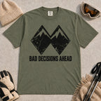 Moss tee featuring a distressed black double-mountain graphic above the phrase “Bad Decisions Ahead.”