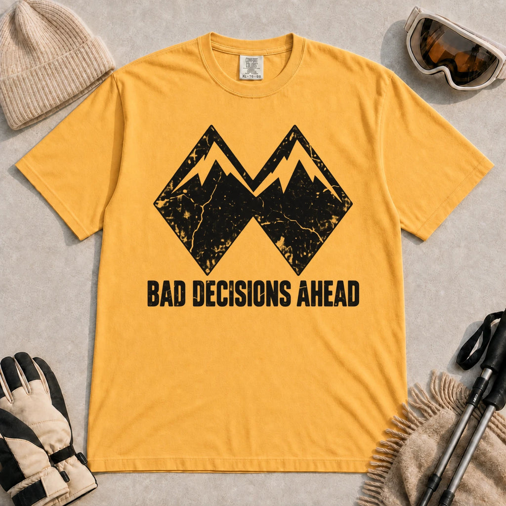 Mustard tee featuring a distressed black double-mountain graphic above the phrase “Bad Decisions Ahead.”
