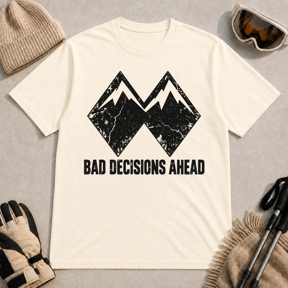 Natural tee featuring a distressed black double-mountain graphic above the phrase “Bad Decisions Ahead.”