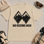 Sand tee featuring a distressed black double-mountain graphic above the phrase “Bad Decisions Ahead.”
