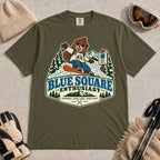 Hemp tee featuring a cheerful bear snowboarding past a blue-square trail sign above the phrase “Blue Square Enthusiast” with “Groomers. Good Vibes. More Runs.”