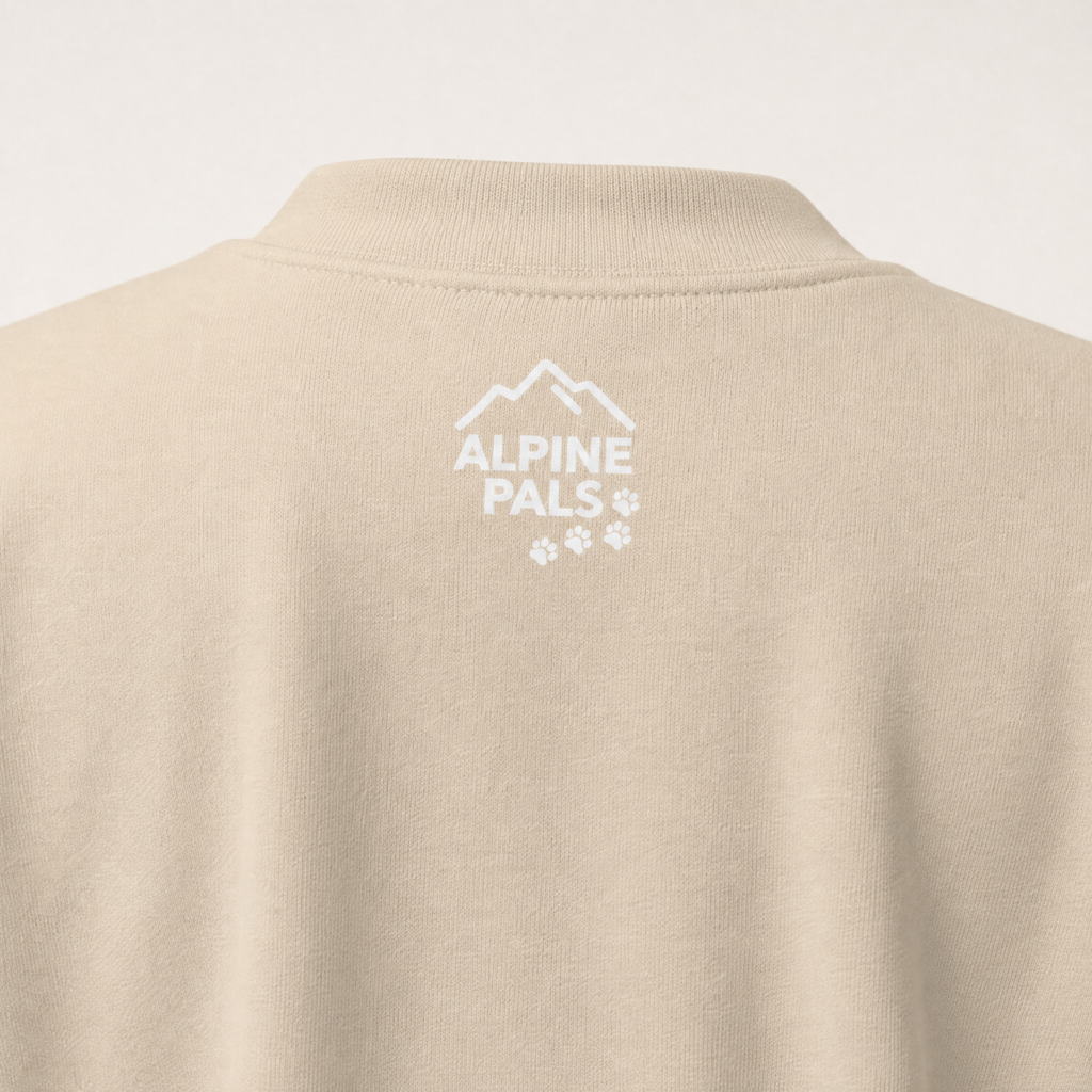 Sand colored sweater with 'Alpine Pals' logo on a white background