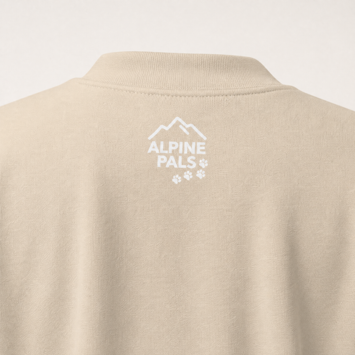 Sand colored sweater with 'Alpine Pals' logo on a white background