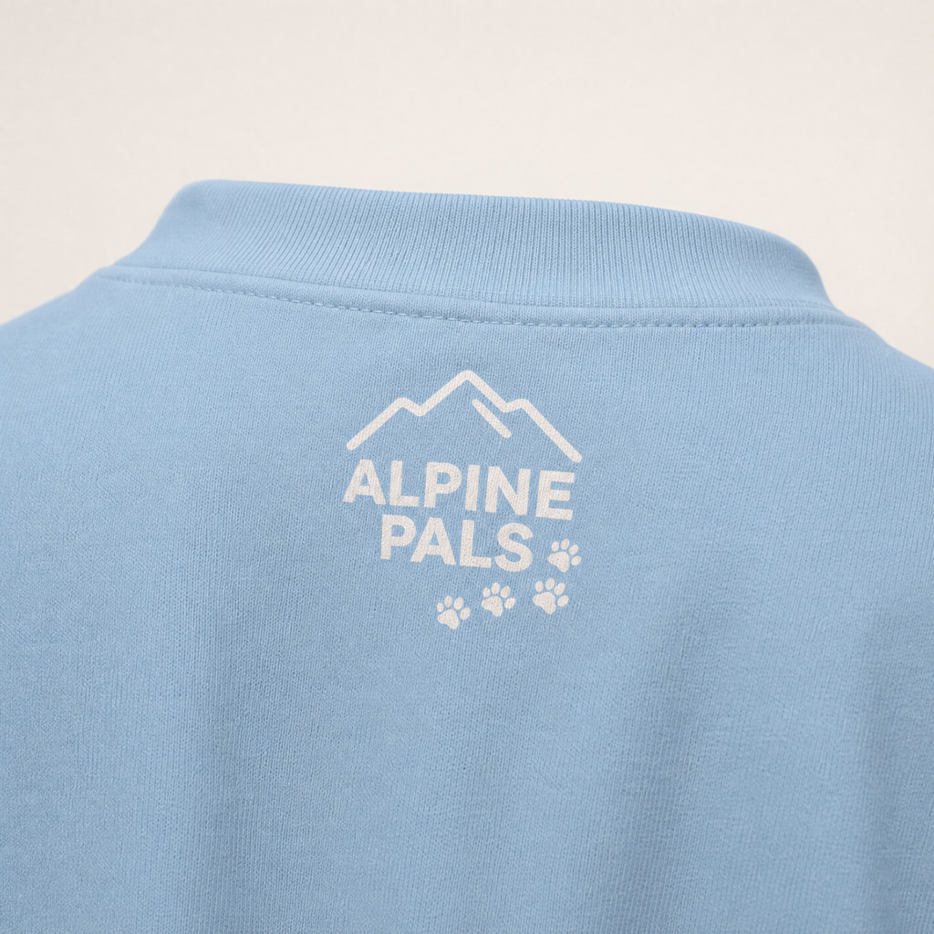 Light blue shirt with 'Alpine Pals' logo on a beige background
