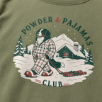 Sweater with a dog in pajamas and skis graphic and 'Powder & Pajamas Club' text on a military green background.