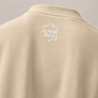 Sand colored sweater with 'Alpine Pals' logo on a gray background