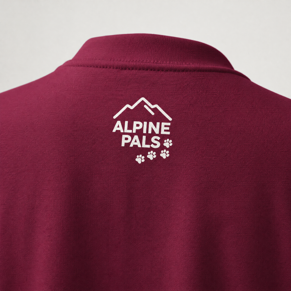 Maroon sweater with 'Alpine Pals' logo on the back against a light gray background