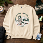 Sand colored sweatshirt with 'Powder & Pajamas Club' design on a wooden surface with winter accessories.