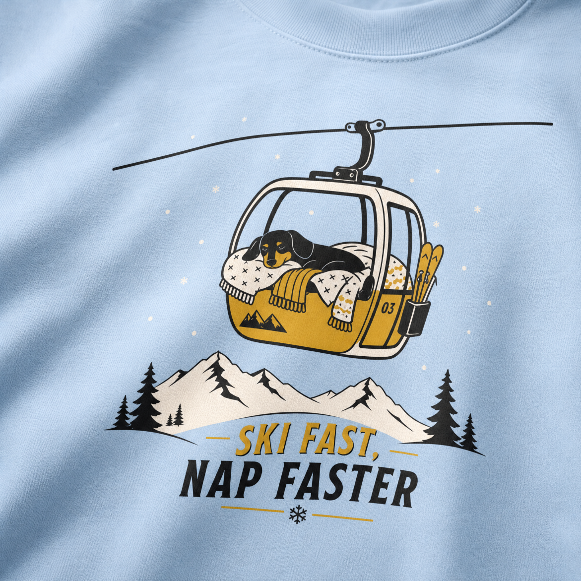 Light blue sweatshirt with a graphic of a dog in a ski lift and 'Ski Fast, Nap Faster' text.