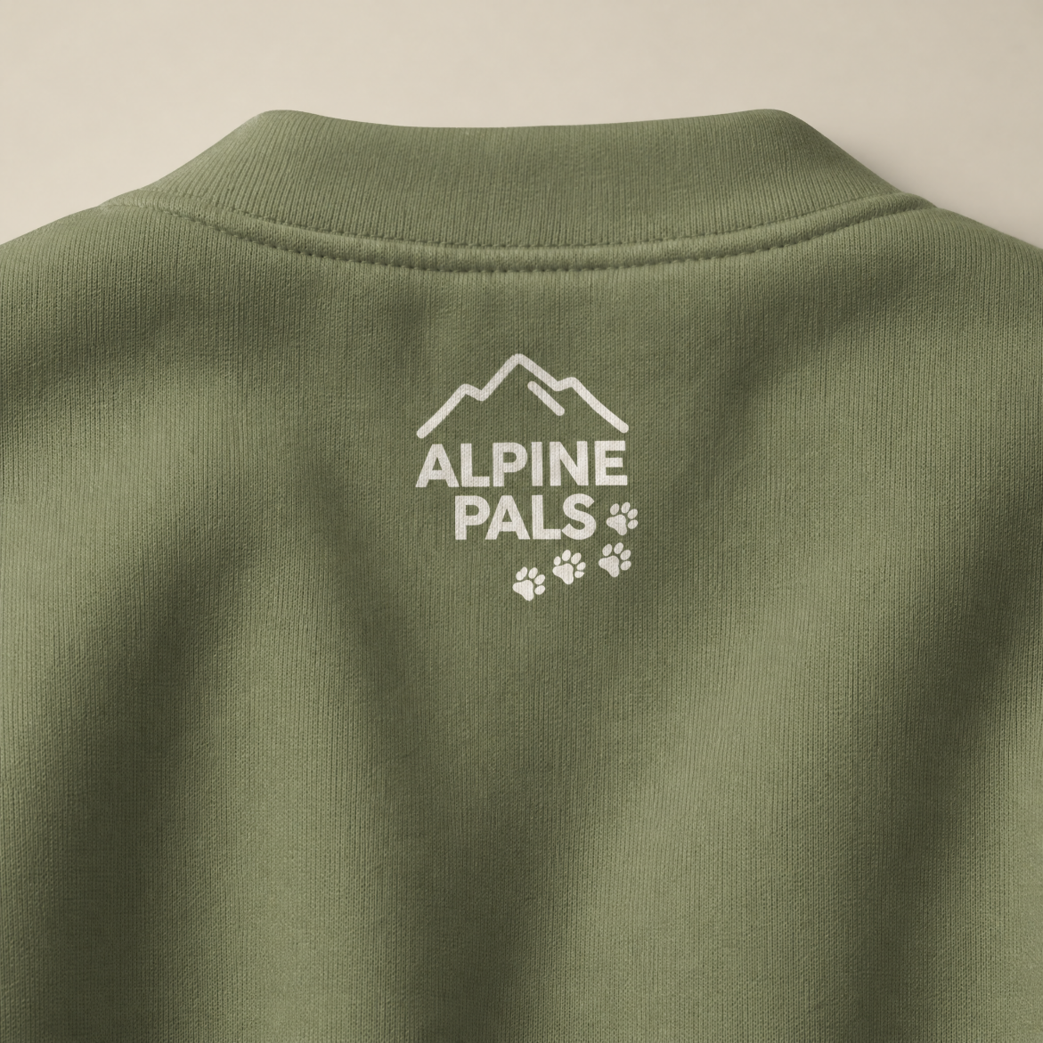 Military green sweatshirt with 'Alpine Pals' logo on a beige background