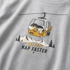 Sport gray t-shirt with a graphic of a dog in a ski lift and 'Ski Fast, Nap Faster' text on a mountain background.