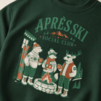 Forest green sweatshirt with 'Après Ski Social Club' graphic featuring animals around a fire.