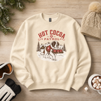 Sand colored sweater with 'HOT COCA PATROL' text and a dog carrying three mugs on a wooden background.