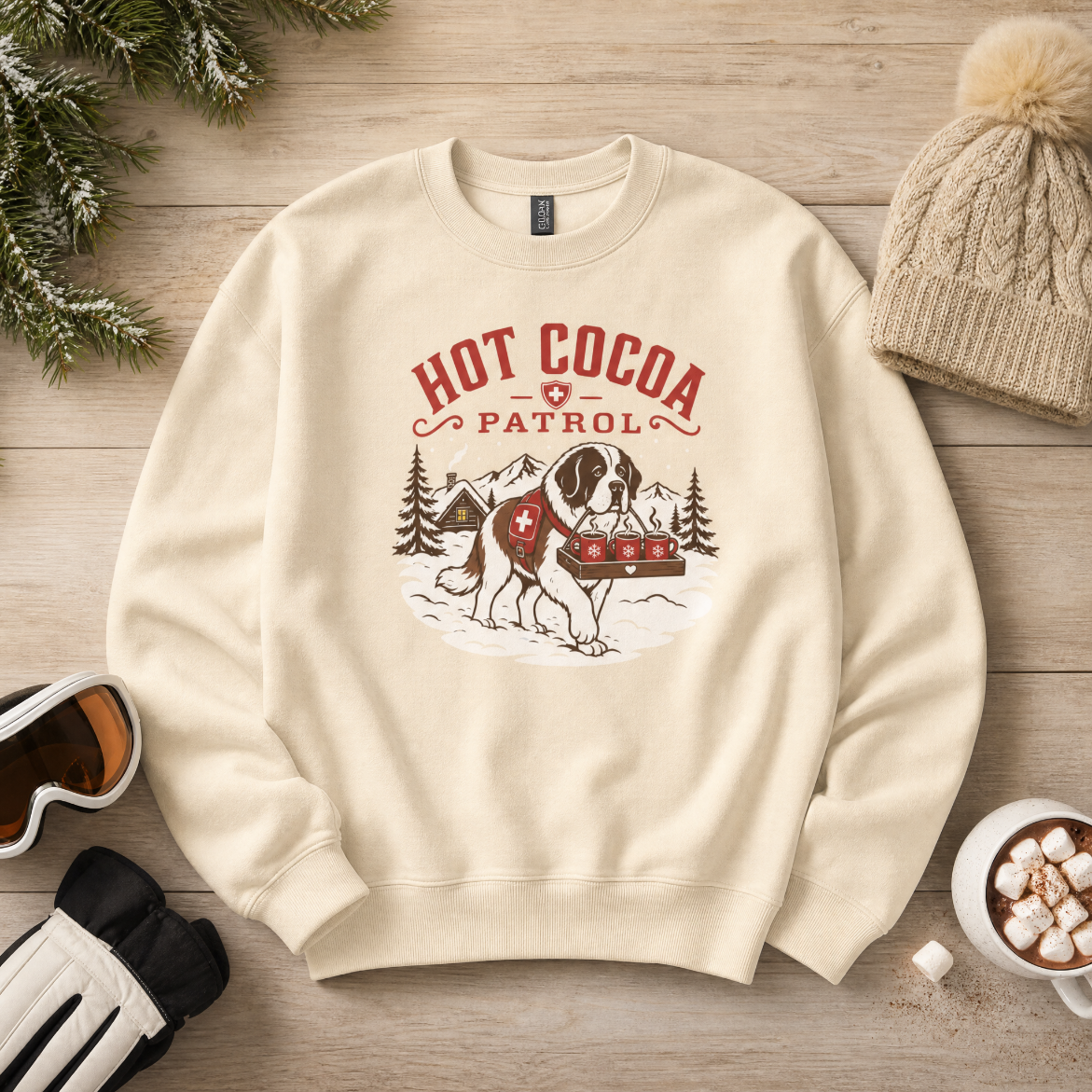 Sand colored sweater with 'HOT COCA PATROL' text and a dog carrying three mugs on a wooden background.