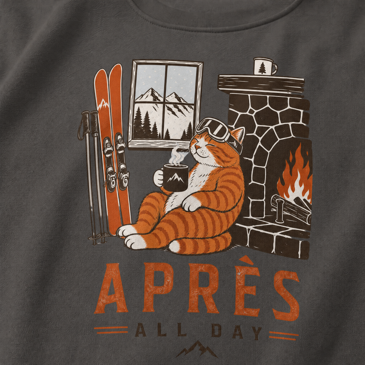 Charcoal gray sweater with a cat by a fireplace and skis, featuring the text 'Après All Day' on a dark background.