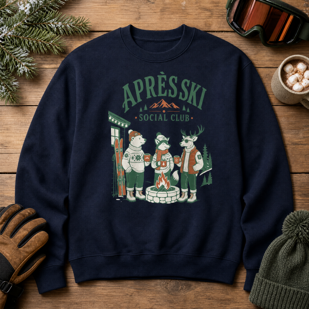 Navy blue sweatshirt with 'Apres Ski Social Club' design on a wooden surface with winter accessories.