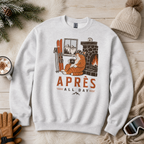 Ash gray sweatshirt with a fox graphic and 'APRES ALL DAY' text on a wooden surface with winter accessories.