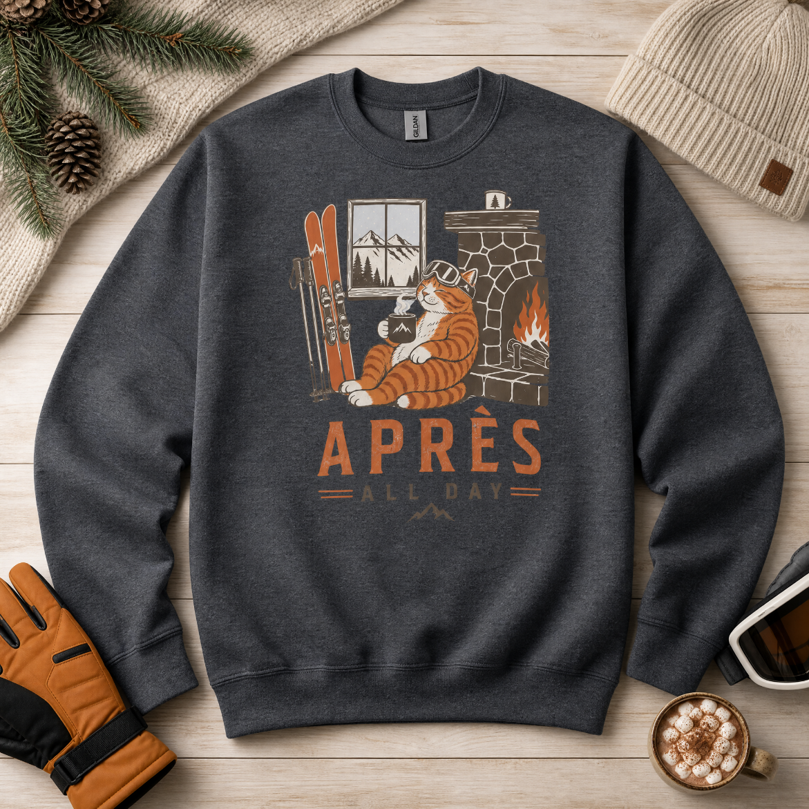 Dark heather gray sweatshirt with a tiger graphic and 'APRES ALL DAY' text on a wooden surface with winter accessories.