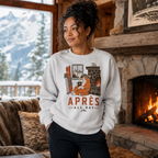 Woman wearing a sweatshirt with a graphic design and text, standing in front of a fireplace with a snowy mountain view.