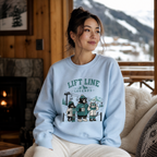 Woman wearing a light blue sweatshirt with a graphic design sitting in a cozy room with a fireplace and snowy mountain view.