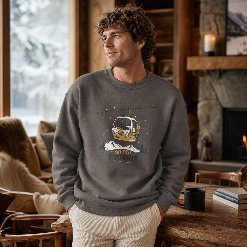 Man wearing a charcoal gray sweatshirt with a graphic design in a cozy indoor setting.