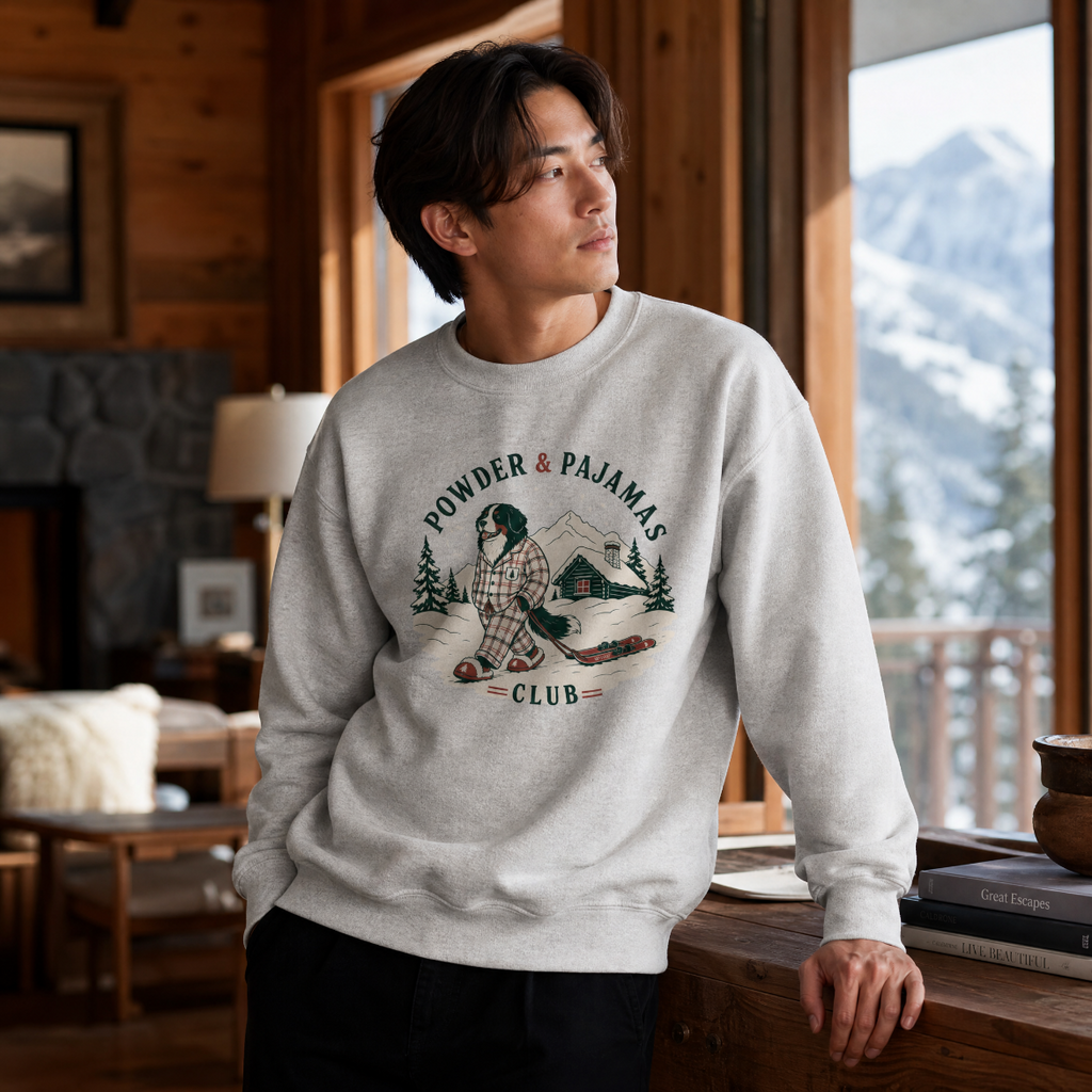 Man wearing an ash gray sweatshirt with a graphic design in a cozy room with a mountain view.