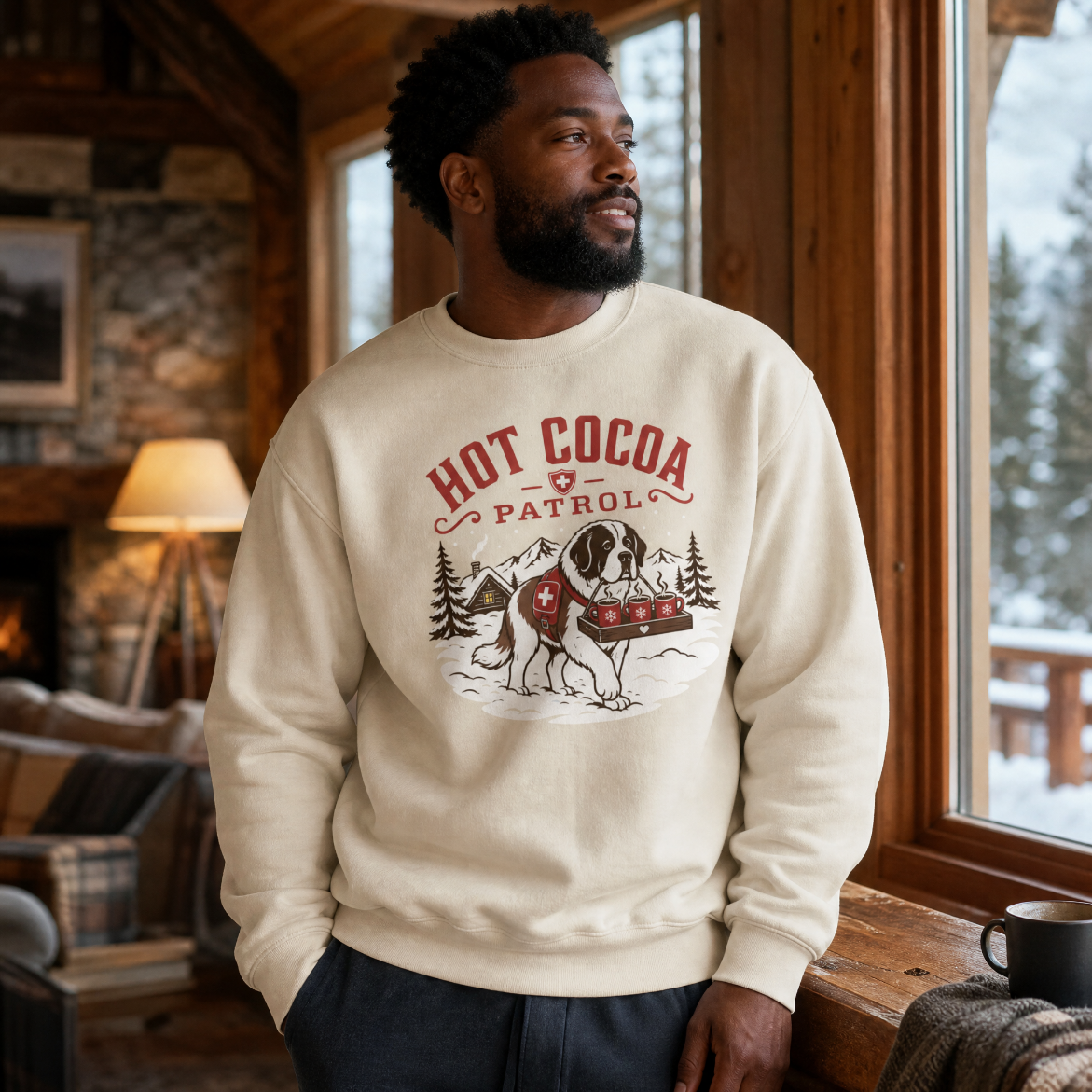 Man wearing a 'Hot Cocoa Patrol' sweatshirt in a cozy cabin setting.
