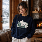 Woman wearing a navy blue sweatshirt with a mountain graphic in a cozy indoor setting.