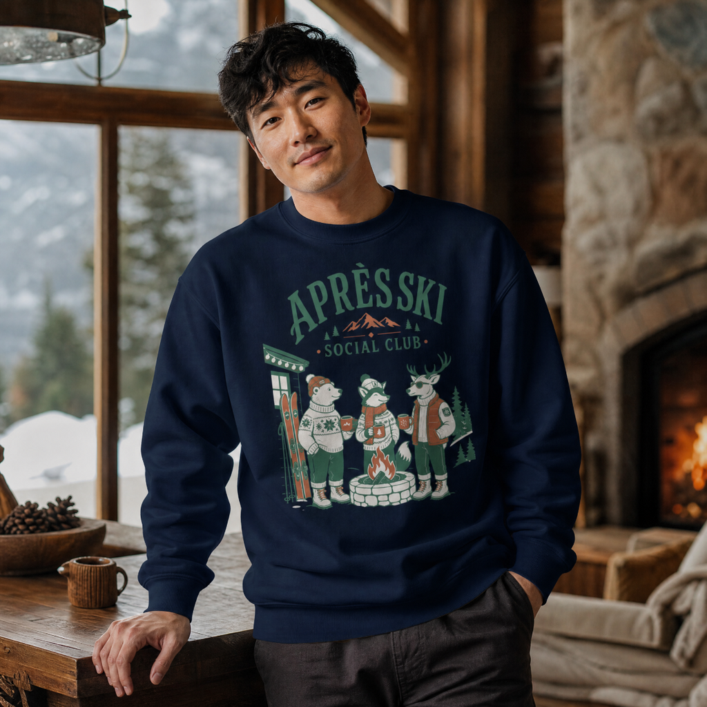 Man wearing a navy blue sweatshirt with 'APRES SKI SOCIAL CLUB' design in a cozy indoor setting.