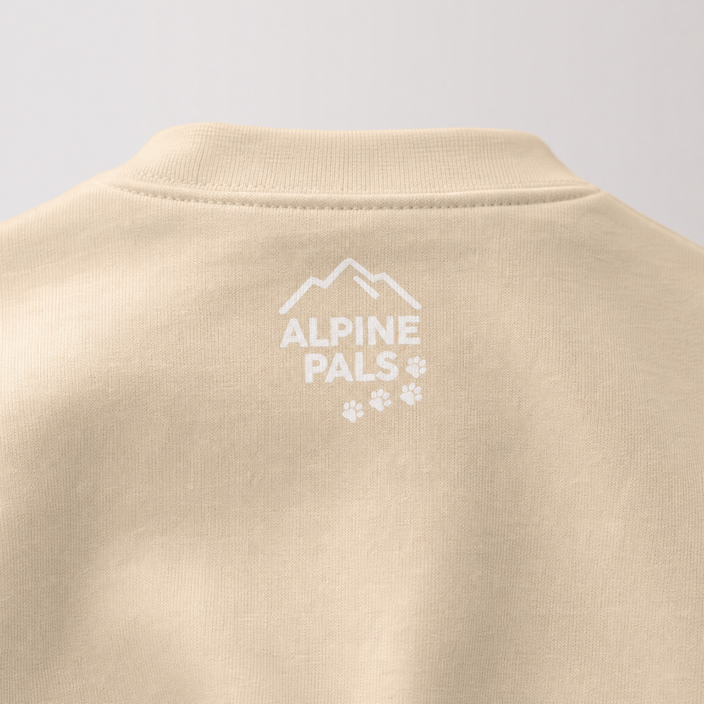Sand colored sweater with 'Alpine Pals' logo on a light gray background