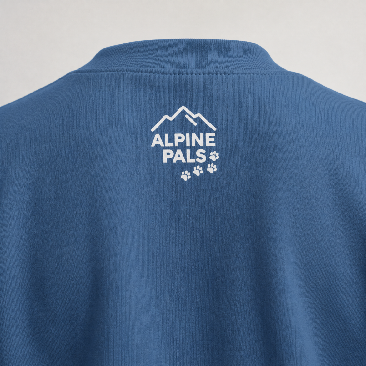 Indigo blue sweater with 'Alpine Pals' logo on a gray background