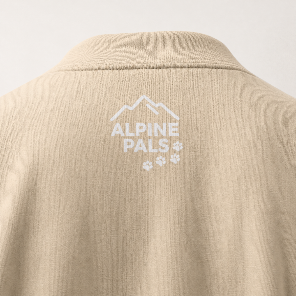 Sand colored sweater with 'Alpine Pals' logo on a white background