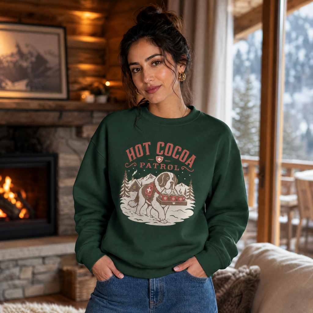 Woman wearing a forest green sweater with 'Hot Cocoa Patrol' text and a dog carrying 3 mugs printed on.