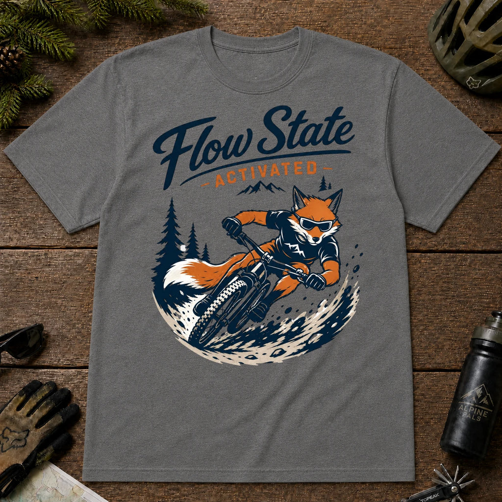 Graphite Heather tee featuring a sunglasses-wearing fox carving a mountain bike berm, with the phrase “Flow State Activated.”
