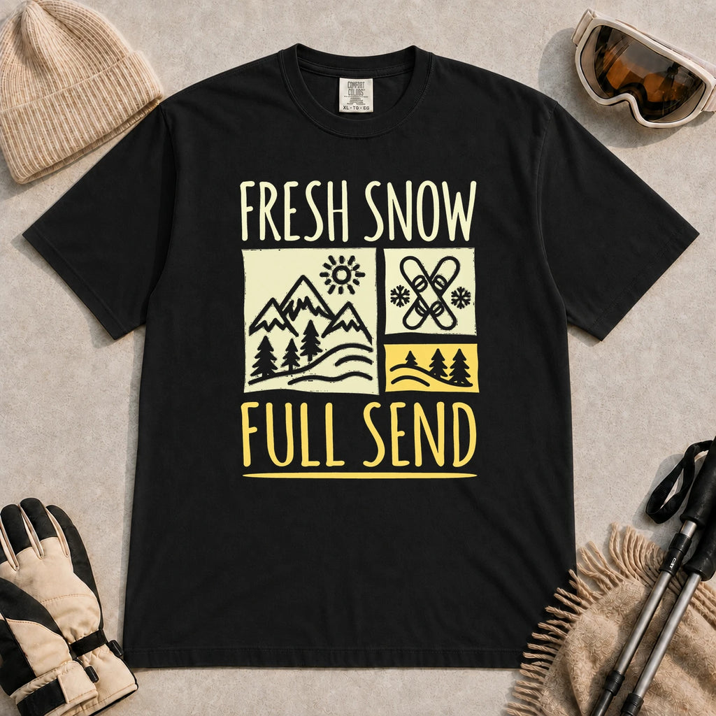 Black tee featuring a retro ski and mountain graphic with the phrase “Fresh Snow, Full Send.”