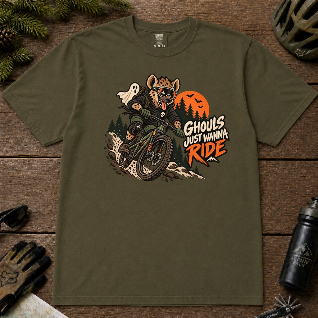 Hemp tee featuring a hyena mountain biking through a spooky Halloween trail scene with a ghost, bats, and orange moon beside the phrase “Ghouls Just Wanna Ride.”