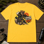 Daisy tee featuring a hyena mountain biking through a spooky Halloween trail scene with a ghost, bats, and orange moon beside the phrase “Ghouls Just Wanna Ride.”