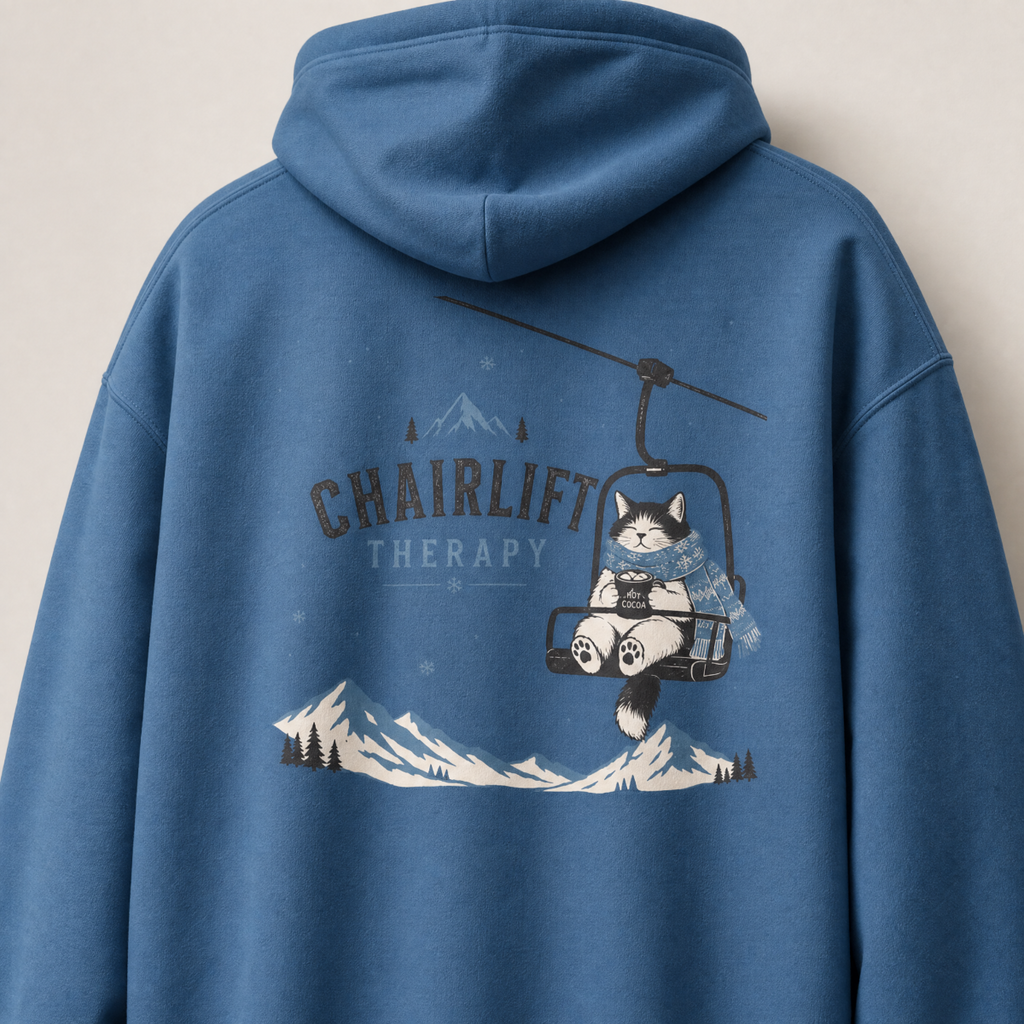 Indigo blue hoodie with a cat on a chairlift graphic and 'Chairlift Therapy' text on the back.