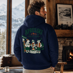 Man wearing a navy hoodie with 'Apres Ski Social Club' design, standing in a cozy room with a fireplace and mountain view.