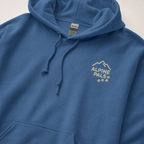 Indigo blue hoodie with 'Alpine Pals' logo on a light gray background