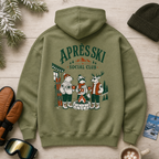 Military green hoodie with 'Après Ski Social Club' design on a wooden surface with winter accessories.