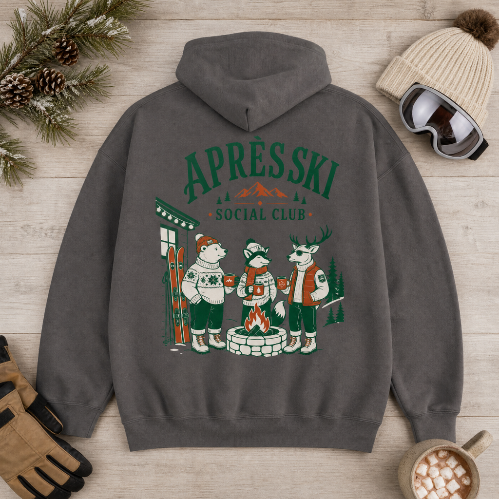 Charcoal gray hoodie with 'Après Ski Social Club' design on a wooden surface with winter accessories.