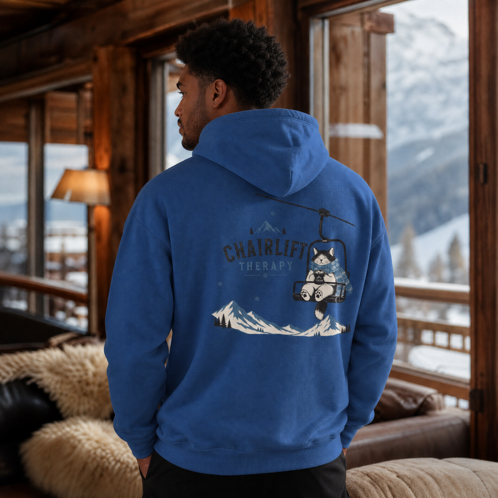 Person wearing an indigo blue hoodie with a chairlift graphic in a mountain cabin setting