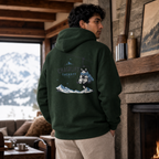Person wearing a forest green hoodie with a mountain and fox design, standing in a cozy room with a fireplace and mountain view.