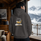 Person wearing a hoodie with a mountain graphic in a cozy room with a view of snow-covered mountains.