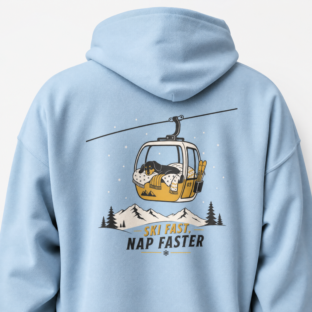 Light blue hoodie with a graphic of a dog in a gondola lift and text 'Ski Fast, Nap Faster' on the back.